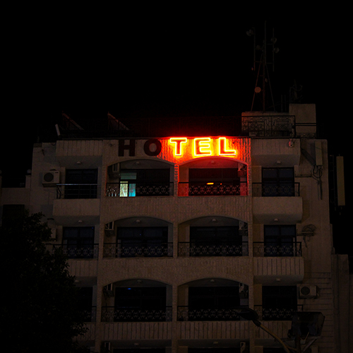 Half burnt-out neon hotel sign.